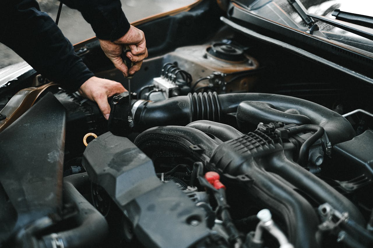 services-02 Close-up of a mechanic working on a car engine. Ideal for auto repair themes.